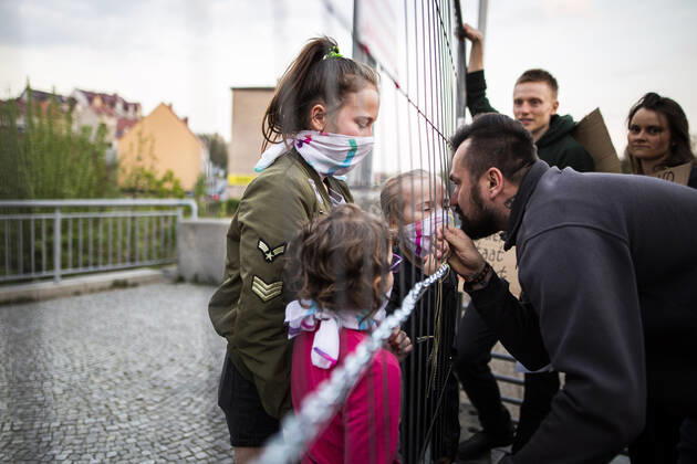 Drei Kinder treffen auf ihren Vater auf der gegenueberliegenden Seite der Grenze im Rahmen der Demonstration gegen die geschlossene Grenze zwischen Zgorzelec und Goerlitz, 24.04.2020. Zur Eindaemmung des Coronaviruses haben unter anderem Polen und Tschechien Mitte Maerz die Grenzen nach Deutschland geschlossen. Hintergrund des Protestes sind die aktuellen Einschraenkungen fuer Arbeiter, die normalerweise taeglich nach Deutschland pendeln, jetzt aber nach Wiedereinreise nach Polen in zweiwoechige Quarantaene muessten. Ausserdem sind grenzuebergreifende, familiaere Kontakte durch die geschlossenen Grenzen schwer moeglich. Goerlitz Deutschland