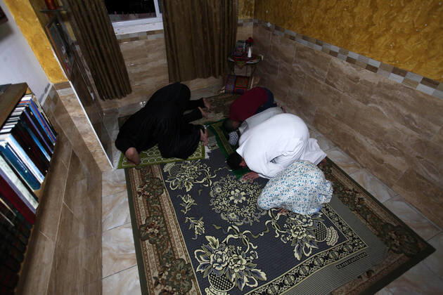 April 24, 2020, Gaza City, Gaza Strip, Palestinian Territory: A Palestinian family performs a night prayer known as Tarawih in their home after the mosques are closed after clerics took protective measures in a bid to stem the spread of the novel coronavirus as a precaution against the spread of the coronavirus (COVID-19), in Gaza City on April 24, 2020. Muslims across the world are preparing for the Islamic holy fasting month of Ramadan, which prohibits eating, drinking, smoking from dawn to dusk Gaza City Palestinian Territory - ZUMAap3_ 20200424_zaf_ap3_232 Copyright: xMahmoudxAjjourx