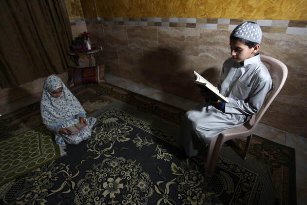 April 24, 2020, Gaza City, Gaza Strip, Palestinian Territory: A Palestinian family reads the Qur™an during a night prayer known as Tarawih in their home after the mosques are closed after clerics took protective measures in a bid to stem the spread of the novel coronavirus as a precaution against the spread of the coronavirus (COVID-19), in Gaza City on April 24, 2020. Muslims across the world are preparing for the Islamic holy fasting month of Ramadan, which prohibits eating, drinking, smoking from dawn to dusk Gaza City Palestinian Territory - ZUMAap3_ 20200424_zaf_ap3_240 Copyright: xMahmoudxAjjourx