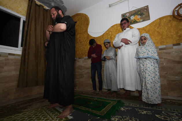 April 24, 2020, Gaza City, Gaza Strip, Palestinian Territory: A Palestinian family performs a night prayer known as Tarawih in their home after the mosques are closed after clerics took protective measures in a bid to stem the spread of the novel coronavirus as a precaution against the spread of the coronavirus (COVID-19), in Gaza City on April 24, 2020. Muslims across the world are preparing for the Islamic holy fasting month of Ramadan, which prohibits eating, drinking, smoking from dawn to dusk Gaza City Palestinian Territory - ZUMAap3_ 20200424_zaf_ap3_260 Copyright: xMahmoudxAjjourx