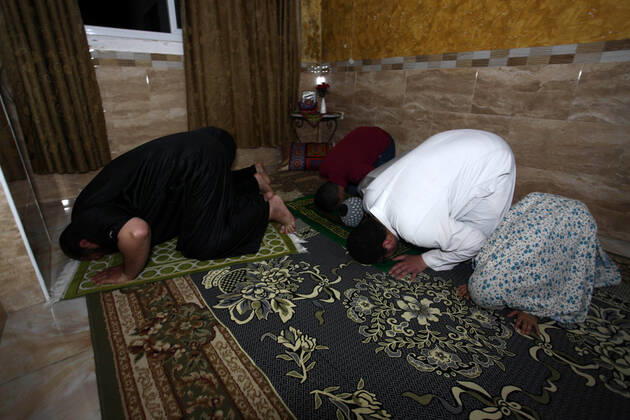 April 24, 2020, Gaza City, Gaza Strip, Palestinian Territory: A Palestinian family performs a night prayer known as Tarawih in their home after the mosques are closed after clerics took protective measures in a bid to stem the spread of the novel coronavirus as a precaution against the spread of the coronavirus (COVID-19), in Gaza City on April 24, 2020. Muslims across the world are preparing for the Islamic holy fasting month of Ramadan, which prohibits eating, drinking, smoking from dawn to dusk Gaza City Palestinian Territory - ZUMAap3_ 20200424_zaf_ap3_261 Copyright: xMahmoudxAjjourx