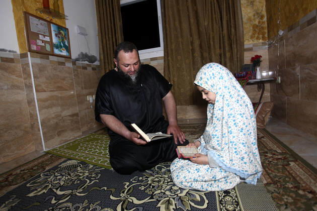 April 24, 2020, Gaza City, Gaza Strip, Palestinian Territory: A Palestinian family reads the Qur™an during a night prayer known as Tarawih in their home after the mosques are closed after clerics took protective measures in a bid to stem the spread of the novel coronavirus as a precaution against the spread of the coronavirus (COVID-19), in Gaza City on April 24, 2020. Muslims across the world are preparing for the Islamic holy fasting month of Ramadan, which prohibits eating, drinking, smoking from dawn to dusk Gaza City Palestinian Territory - ZUMAap3_ 20200424_zaf_ap3_264 Copyright: xMahmoudxAjjourx