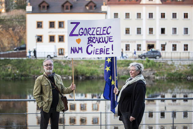Demonstranten protestieren mit einem Schild mit der Aufschrift Zgorzelec brakuje nam ciebie (Zgorzelec fehlt uns!) gegen die geschlossene Grenze zwischen Zgorzelec und Goerlitz, 24.04.2020. Zur Eindaemmung des Coronaviruses haben unter anderem Polen und Tschechien Mitte Maerz die Grenzen nach Deutschland geschlossen. Hintergrund des Protestes sind die aktuellen Einschraenkungen fuer Arbeiter, die normalerweise taeglich nach Deutschland pendeln, jetzt aber nach Wiedereinreise nach Polen in zweiwoechige Quarantaene muessten. Ausserdem sind grenzuebergreifende, familiaere Kontakte durch die geschlossenen Grenzen schwer moeglich. Goerlitz Deutschland