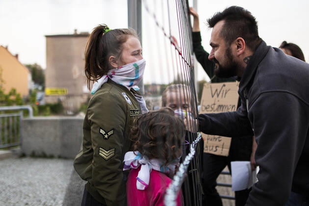 Ein Kind trifft auf sein Vater auf der gegenueberliegenden Seite der Grenze im Rahmen der Demonstration gegen die geschlossene Grenze zwischen Zgorzelec und Goerlitz, 24.04.2020. Zur Eindaemmung des Coronaviruses haben unter anderem Polen und Tschechien Mitte Maerz die Grenzen nach Deutschland geschlossen. Hintergrund des Protestes sind die aktuellen Einschraenkungen fuer Arbeiter, die normalerweise taeglich nach Deutschland pendeln, jetzt aber nach Wiedereinreise nach Polen in zweiwoechige Quarantaene muessten. Ausserdem sind grenzuebergreifende, familiaere Kontakte durch die geschlossenen Grenzen schwer moeglich. Goerlitz Deutschland