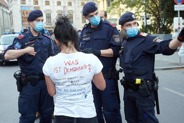 - Wien 24.04.2020 - Coronavirus Krise - Heute am Nachmittag gab es am Platz vor der Albertina in der Wiener innenstadt eine mehrfach angesagte und wieder abgesagte und dann verbotene Demonstration gegen die von der Regierung beschlossenen Massnahmen im Rahmen der Coronavirus Pandemie. Einige Hundert Menschen kamen zusammen bis die Polizei eingeschritten ist um die restlichen Demonstranten die sich laut Polizei nicht an die Abstandregelung hielten erkennungsdienstlich zu behandeln. Dabei kam es auch zu Handgreiflichkeiten, Festnahmen sowie zu einem Rettungseinsatz. PHOTO: Eine der Kundgebungsteilnehmerinnen muss sich den Polizisten der Bereitschaftspolizei gegenüber ausweisen. Vienna, Austria - Coronavirus Crisis - This afternoon in the square in front of the Albertina in Vienna s city center there was a popular and then forbidden 