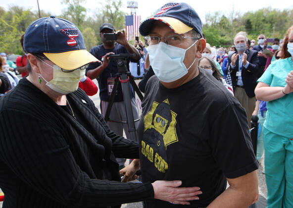 St. Louis Metropolitan motorcycle Police Officer Dave Tenorio is greeted by his wife Kathy for the first time, during a celebration discharge, at St. Luke s Hospital, in Chesterfield, Missouri on Friday, April 24, 2020. After being admitted on April 1,Tenorio is St. Luke s first COVID-19 patient to be treated with ECMO (extracorporeal membrane oxygenation) and is the first known COVID-19 patient in the St. Louis region to be treated with ECMO and be released. ECMO acts as an outside heart and lung to support the body when a person?s own organs are too sick to do the job. It extracts blood, adds oxygen and pumps blood back into the body.  SLP2020042413 BILLxGREENBLATT