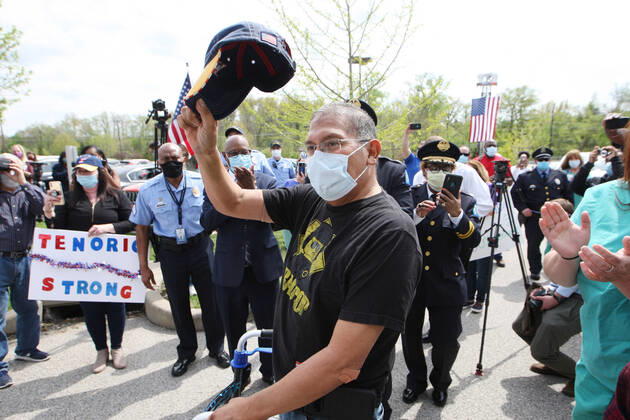 St. Louis Metropolitan motorcycle Police Officer Dave Tenorio waves his cap during a celebration discharge, at St. Luke s Hospital, in Chesterfield, Missouri on Friday, April 24, 2020. After being admitted on April 1,Tenorio is St. Luke s first COVID-19 patient to be treated with ECMO (extracorporeal membrane oxygenation) and is the first known COVID-19 patient in the St. Louis region to be treated with ECMO and be released. ECMO acts as an outside heart and lung to support the body when a person s own organs are too sick to do the job. It extracts blood, adds oxygen and pumps blood back into the body.  SLP2020042414 BILLxGREENBLATT