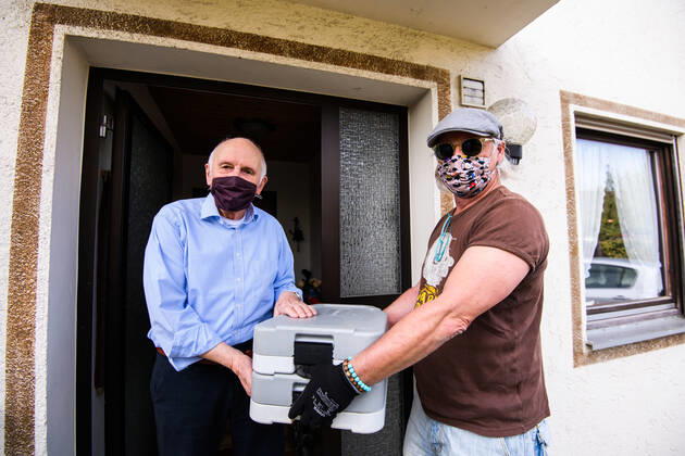 (200425) -- ROSENHEIM, April 25, 2020 (Xinhua) -- Volunteer Martin Leopoldseder (R) delivers free meal from restaurant Fischkueche to a man in Rosenheim, southern Germany, April 24, 2020. As the COVID-19 hit southern German city Rosenheim, Fischkueche (Fish Kitchen), a restaurant with a history of more than 100 years, has provided nearly 2,000 free meals with free delivery by volunteers to local people needing help in recent five weeks. (Photo by Kevin Voigt Xinhua) GERMANY-ROSENHEIM-COVID-19-FREE MEALS 