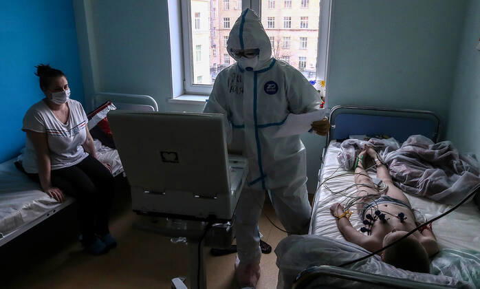 MOSCOW, RUSSIA - APRIL 24, 2020: A medical staff member in protective gear does an ECG test on a young patient as the parent looks on in the centre for infectious diseases, which opened on 20 April 2020 at the National Medical Research Centre for Children s Health (NMITS) to treat young patients with suspected or confirmed novel coronavirus infection (COVID-19). The medical facility has 300 beds, an additional 30 beds in the intensive care unit, and 8 operating rooms. Valery Sharifulin TASS  TS0D704E