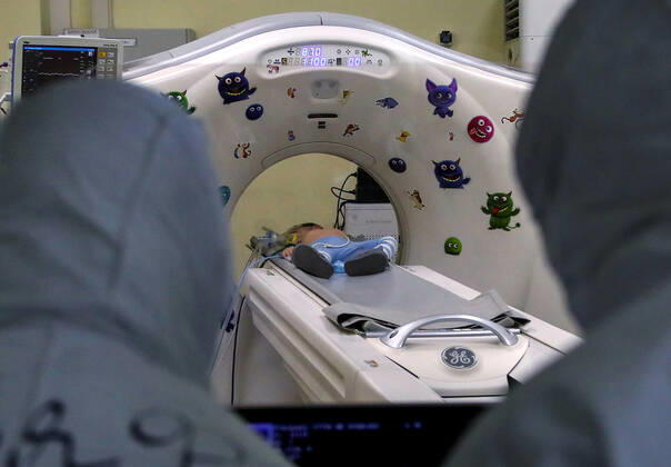 MOSCOW, RUSSIA - APRIL 24, 2020: Medical staff members in protective gear look on as a young patient undergoes a CT scan in the centre for infectious diseases, which opened on 20 April 2020 at the National Medical Research Centre for Children s Health (NMITS) to treat young patients with suspected or confirmed novel coronavirus infection (COVID-19). The medical facility has 300 beds, an additional 30 beds in the intensive care unit, and 8 operating rooms. Valery Sharifulin TASS  TS0D7052