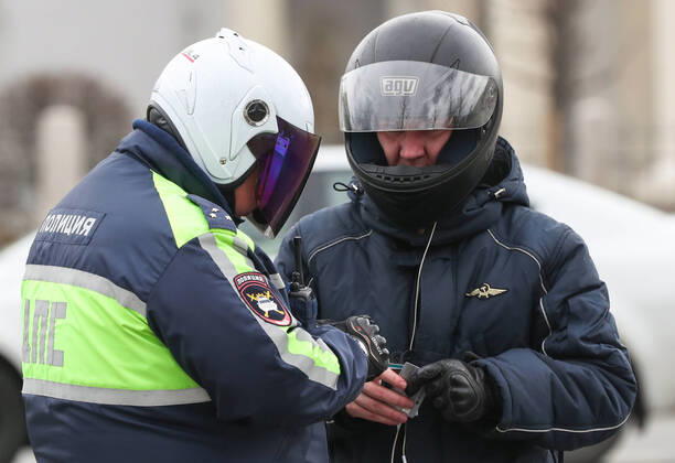 MOSCOW, RUSSIA - APRIL 25, 2020: Traffic police officers in helmets and face masks carry out an ID check during the pandemic of the novel coronavirus disease (COVID-19). Since 30 March, Moscow has been on lockdown. Traffic police have set up checkpoints around the city to stop vehicles and see if drivers have permission to travel during the lockdown. On 13 April 2020, the Moscow government introduced a digital permit system aimed at further restricting movement. Under the scheme, which became mandatory on 15 April, people need to apply for permits to travel on a vehicle or public transport around the city. As of 25 April 2020, Russia has reported more than 68,700 confirmed cases of the novel coronavirus infection, with more than 36,800 confirmed cases in Moscow. Vladimir Gerdo TASS TS0D705C