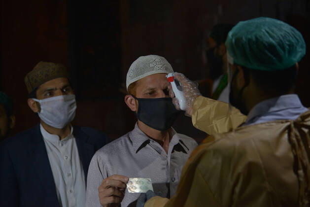 Coronavirus in Pakistan, Eindrücke von der Data Darbar Moschee in Lahore Security officials check the body temperature Pakistani security officials checks the body temperature of a man as arriving for offering first Namaz-e-Taraweeh at Data Darbar Mosque after sighting the moon of Holy Fasting month of Ramadan-ul-Mubarak during a government-imposed nationwide lockdown as a preventive measures while maintaining a level of social distancing to help avoid the spread of the coronavirus,at Data Darbar mosque in Lahore. Lahore Punjab Pakistan Copyright: RanaxSajidxHussain