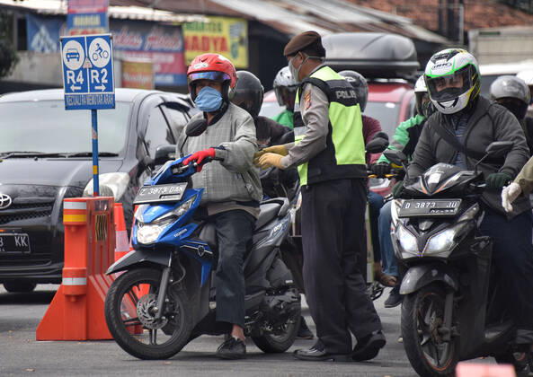Coronavirus in Indonesien, Eindrücke aus Bandung Large-scale social restrictions In Bandung, Indonesia - 25 Apr 2020. A Police control traffic road users during the implementation of the large-scale social restrictions at a? checkpoint in Bandung, West Java. April 25, 2020. Large-scale social restrictions in the city of Bandung carried out to break the spread of coronavirus COVID-19. (Ph?oto by Rizal Fadillah INA Photo Agency imago images) 
