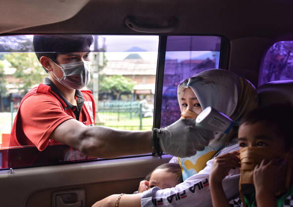 Coronavirus in Indonesien, Eindrücke aus Bandung Large-scale social restrictions In Bandung, Indonesia - 25 Apr 2020. A Medical worker checking road users temperature body as a measure prevent COVID-19 during the implementation of the large-scale social restrictions at a? checkpoint in Bandung, West Java. April 25, 2020. Large-scale social restrictions in the city of Bandung carried out to break the spread of coronavirus COVID-19. (Ph?oto by Rizal Fadillah INA Photo Agency imago images) 