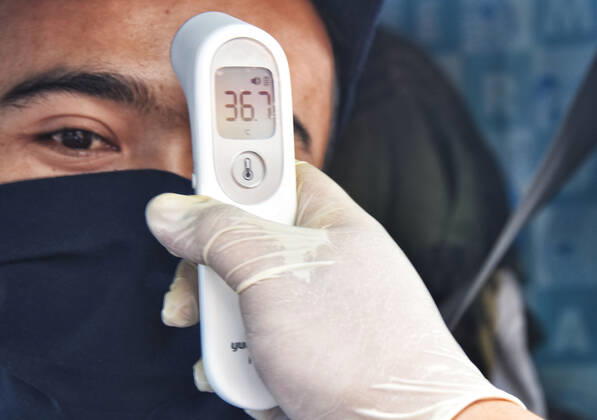 Coronavirus in Indonesien, Eindrücke aus Bandung Large-scale social restrictions In Bandung, Indonesia - 25 Apr 2020. A Medical worker checking road users temperature body as a measure prevent COVID-19 during the implementation of the large-scale social restrictions at a? checkpoint in Bandung, West Java. April 25, 2020. Large-scale social restrictions in the city of Bandung carried out to break the spread of coronavirus COVID-19. (Ph?oto by Rizal Fadillah INA Photo Agency imago images) 