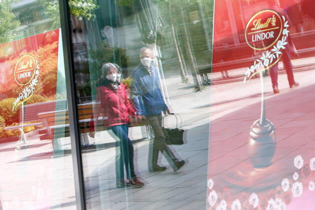 25.04.2020, xtgx, Folgen des Corona Virus in Wolfsburg, Kunden mit Masken spiegeln sich im Schaufenster im Designer Outlet Wolfsburg (DOW, Outlet Center). In Wolfsburg gilt eine Pflicht, in allen Geschaeften und in Bussen eine Maske zu tragen, die Mund und Nase bedeckt. Symbolfoto Mundschutzpflicht, Mundschutz, Maske, Maskenpflicht, Einkaufen, Konsum, Wirtschaft, Shopping. Wolfsburg