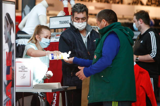 25.04.2020, xtgx, Folgen des Corona Virus in Wolfsburg, Kunden mit Masken werden die Haende desinfiziert im Designer Outlet Wolfsburg (DOW, Outlet Center). In Wolfsburg gilt eine Pflicht, in allen Geschaeften und in Bussen eine Maske zu tragen, die Mund und Nase bedeckt. Symbolfoto Mundschutzpflicht, Mundschutz, Maske, Maskenpflicht, Einkaufen, Konsum, Wirtschaft, Shopping. Wolfsburg