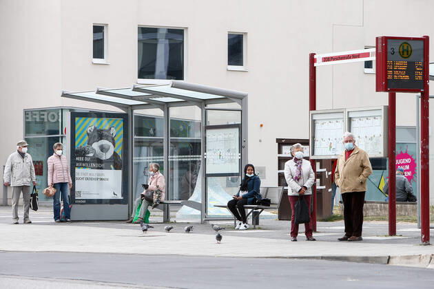 25.04.2020, xtgx, Folgen des Corona Virus in Wolfsburg, Fahrgaeste warten mit Masken im Gesicht auf ihren Bus. In Wolfsburg gilt eine Pflicht, in allen Geschaeften und in Bussen eine Maske zu tragen, die Mund und Nase bedeckt. Wolfsburg