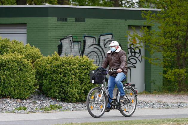 25.04.2020, xtgx, Folgen des Corona Virus in Wolfsburg, ein Radfahrer mit Maske. In Wolfsburg gilt eine Pflicht, in allen Geschaeften und in Bussen eine Maske zu tragen, die Mund und Nase bedeckt. Wolfsburg