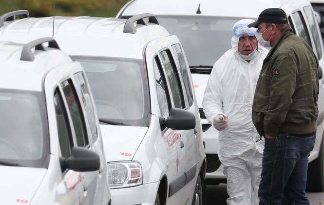 MOSCOW, RUSSIA â€“ APRIL 25, 2020: A medical staff worker in protective gear talks to a man in a face mask next to medical service vehicles at the Novomoskovsky multipurpose medical centre for patients with suspected COVID-19 coronavirus infection, in Kommunarka, Novomoskovsky Administrative District of Moscow. As of 25 April 2020, Russia has reported more than 68,700 confirmed cases of the novel coronavirus, with more than 36,800 confirmed cases in Moscow. Gavriil Grigorov TASS  TS0D70F1