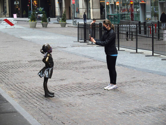 April 25, 2020, New York, New York, USA: Covid19 Pandemic New York City people discard gloves and masks, walk around Manhattan without masks, disregard social distancing. Tourist take a photograph of The Fearless girl statue in front of The New York Stock Exchange. New York USA - ZUMAct2_ 20200425_zaf_ct2_011 Copyright: xBrucexCotlerx