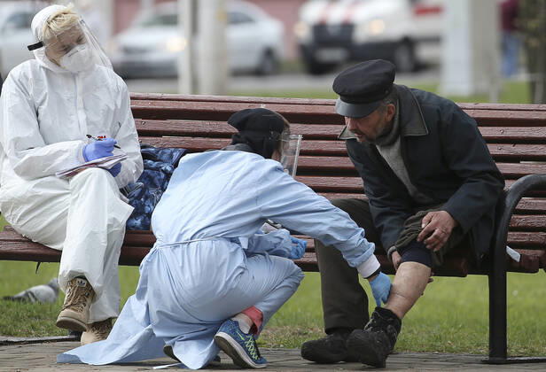 MINSK, BELARUS - APRIL 25, 2020: Volunteers provide medical care to a homeless man in Minsk s Mikhailovsky Garden Square. Natalia Fedosenko TASS  TS0D7105