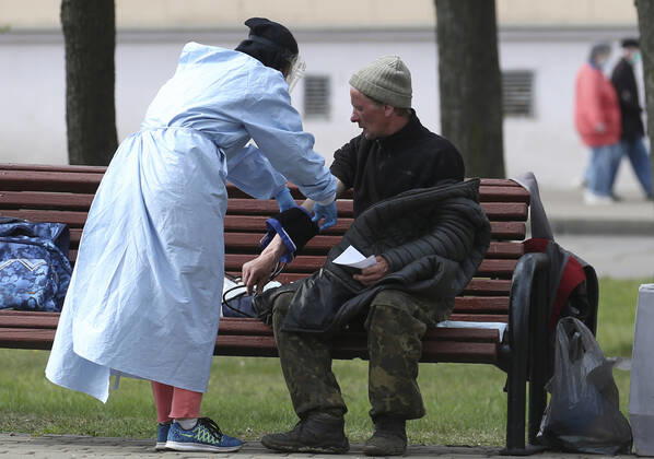 MINSK, BELARUS - APRIL 25, 2020: A volunteer checks a homeless man s blood pressure in Minsk s Mikhailovsky Garden Square. Natalia Fedosenko TASS  TS0D7107