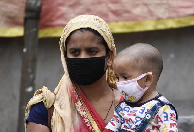 April 25, 2020, Guwahati, Assam, India: A woman with her child arrived at Adabari bus stop to catch a bus, state authorities eased restrictions on inter-district travel for three days, during the nationwide lockdown to curb the spread of coronavirus, in Guwahati. Guwahati India - ZUMAt232 20200425_zip_t232_002 Copyright: xDavidxTalukdarx