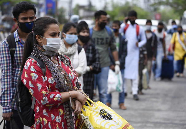 April 25, 2020, Guwahati, Assam, India: People in queue at Adabari bus stop to catch a bus, state authorities eased restrictions on inter-district travel for three days, during the nationwide lockdown to curb the spread of coronavirus, in Guwahati. Guwahati India - ZUMAt232 20200425_zip_t232_010 Copyright: xDavidxTalukdarx