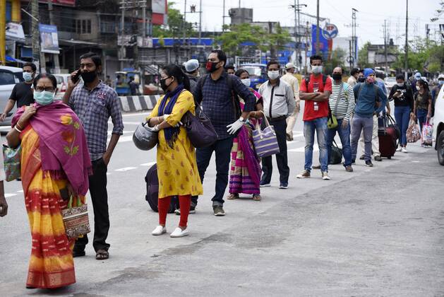 April 25, 2020, Guwahati, Assam, India: People in queue at Adabari bus stop to catch a bus, state authorities eased restrictions on inter-district travel for three days, during the nationwide lockdown to curb the spread of coronavirus, in Guwahati. Guwahati India - ZUMAt232 20200425_zip_t232_017 Copyright: xDavidxTalukdarx
