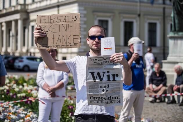April 25, 2020, Munich, Bavaria, Germany: We are the opposition from an anti-state, far-right grouping along with Give Bill Gates no chance held during a QAnon-like demo in Munich, Germany. Organized in Telegram chats by conspiratorial â€oeQuerfront†(cross-front) groups, the city of Munich, Germany saw numerous QAnon-like, â€oeCorona Parties†as under mottos such as â€oeDemonstration fuer die Erhaltung der Grundrechte†(Demonstration for the Upholding of Basic Rights) and â€oeFuer unsere Freiheit, unsere Grundrechte und unsere Selbstbestimmung†(Demonstration for our Freedom, Basic Rights, and Self-Determination). Numerous right-extremists, Verfassungsschutz-monitored figures, QAnon fans, and AfD politicians were in attendance. The groups are of the belief that the anti-Coronavirus measures - ZUMAb160 20200425_zbp_b160_008 Copyright: xSachellexBabbarx