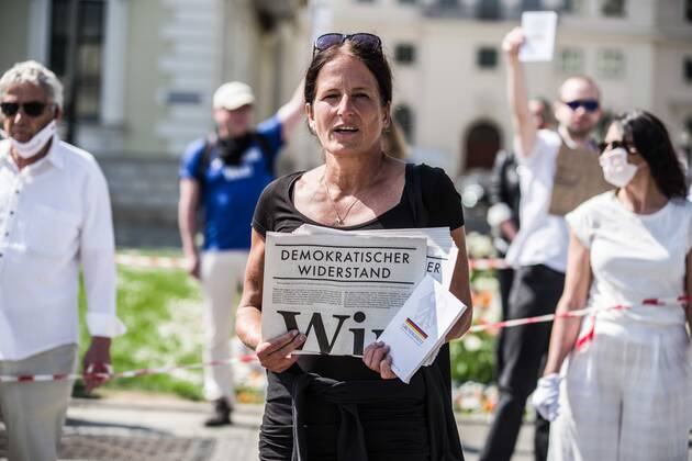 April 25, 2020, Munich, Bavaria, Germany: A demonstrator at a QAnon-like demo in Munich, Germany holds the newspaper of NichtOhneUns. Organized in Telegram chats by conspiratorial â€oeQuerfront†(cross-front) groups, the city of Munich, Germany saw numerous QAnon-like, â€oeCorona Parties†as under mottos such as â€oeDemonstration fuer die Erhaltung der Grundrechte†(Demonstration for the Upholding of Basic Rights) and â€oeFuer unsere Freiheit, unsere Grundrechte und unsere Selbstbestimmung†(Demonstration for our Freedom, Basic Rights, and Self-Determination). Numerous right-extremists, Verfassungsschutz-monitored figures, QAnon fans, and AfD politicians were in attendance. The groups are of the belief that the anti-Coronavirus measures are power-grabs. Querfront groups are often a mix of political - ZUMAb160 20200425_zbp_b160_021 Copyright: xSachellexBabbarx