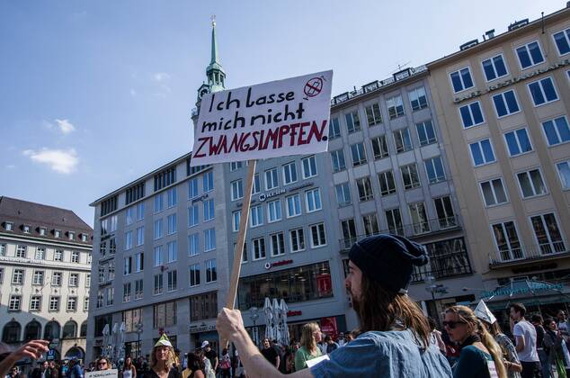 April 25, 2020, Munich, Bavaria, Germany: An anti-vaxxer displays a sign opposing vaccines at a QAnon-like demo in Munich, Germany. Organized in Telegram chats by conspiratorial â€oeQuerfront†(cross-front) groups, the city of Munich, Germany saw numerous anti-state â€oeCorona Parties†as under mottos such as â€oeDemonstration fuer die Erhaltung der Grundrechte†(Demonstration for the Upholding of Basic Rights) and â€oeFuer unsere Freiheit, unsere Grundrechte und unsere Selbstbestimmung†(Demonstration for our Freedom, Basic Rights, and Self-Determination). Numerous right-extremists, Verfassungsschutz-monitored figures, QAnon fans, and AfD politicians were in attendance. The groups are of the belief that the anti-Coronavirus measures are power-grabs. Querfront groups are often a mix of political ou - ZUMAb160 20200425_zbp_b160_068 Copyright: xSachellexBabbarx