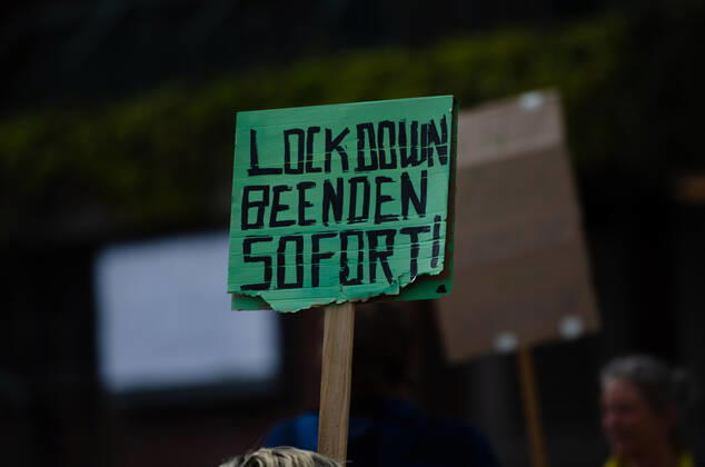 Lockdown beenden sofort! - Demonstration auf dem Südermarkt von Flensburg Die Kommunikationsstelle Demokratischer Widerstand veranstaltet eine Demonstration am 25.04.2020 in Flensburg auf dem Südermarkt, Innenstadt; Demontrant hält Transparent mit der Aufschrift Lockdown beenden sofort!