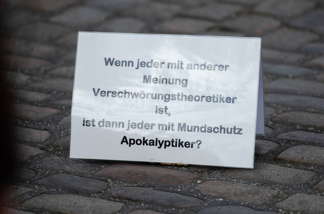 Lockdown beenden sofort! - Demonstration auf dem Südermarkt von Flensburg Die Kommunikationsstelle Demokratischer Widerstand veranstaltet eine Demonstration am 25.04.2020 in Flensburg auf dem Südermarkt, Innenstadt; hier: Transparent mit der Aufschrift Wenn jeder mit anderer Meinung Verschwörungstheoretiker ist, ist dann jeder mit Mundschutz Apokalyptiker?