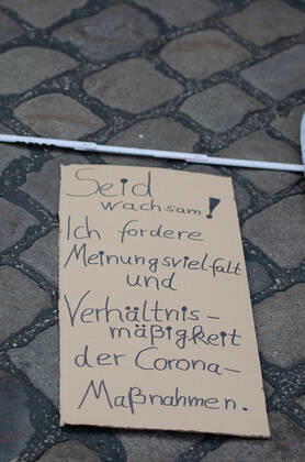 Lockdown beenden sofort! - Demonstration auf dem Südermarkt von Flensburg Die Kommunikationsstelle Demokratischer Widerstand veranstaltet eine Demonstration am 25.04.2020 in Flensburg auf dem Südermarkt, Innenstadt; hier: Transparent mit der Aufschrift Sied wachsam! Ich fordere Meinungsvielfalt und Verhältnismäßigkeit der Corona-Maßnahmen