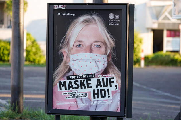 Die Stadt Heidelberg bittet die Heidelberger Bevölkerung mit einer Plakataktion, sich ab Montag, den 27. April 2020, an die dann geltende Maskenpflicht zu halten, um sich und andere vor einer Ansteckung mit dem Coronavirus zu schützen, das Plakat zeigt eine Frau mit Mundschutz und der Aufschrift: Protect Others, Maske auf, HD!, Plakatmotiv: Sigrid Zweygart-Perez (Pfarrerin, Evangelische Kirche), Plakate, Hinweis, Hinweistafel, Hinweisschild, Corona, Schutz, Selbstschutz, Verordnung, behördliche Anweisung, Auflage, Gebot, Verhaltensregel, Maßnahme, Symbolfoto, Symbolbild, Symbol, 25.04.2020, Heidelberg (Deutschland), Feature, Coronavirus, Impressionen aus Heidelberg