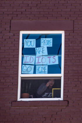 April 25, 2020, El Paso, Texas: A person sticks the middle finger to protestors outside their home gathering during a Reopen Texas rally in El Paso, Texas. Non-essential personal in El Paso and other cities in Texas continue to remain under stay-at-home orders due to the coronavirus outbreak. El Paso - ZUMAj106 20200425_zap_j106_006 Copyright: xJoelxAngelxJuarezx