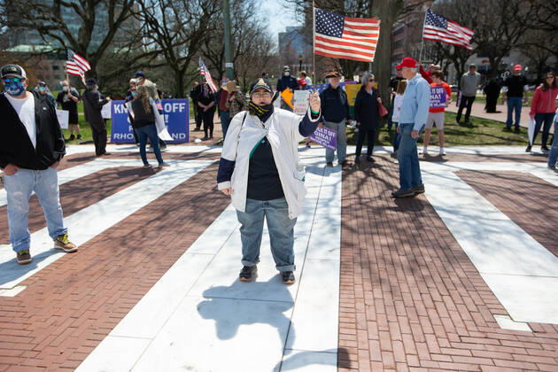 A woman holds an American Flag during the Rhode Islanders against excessive quarantine protest in reaction to the state s mandatory stay-at-home order as an attempt to combat COVID-19 at the Rhode Island State House in Providence, Rhode Island on Saturday, April 25, 2020. Rhode Island Governor Gina Raimondo has extended the stay-at-home order in an effort to combat the spread of COVID-19 to May 8th and recently told schools that they will finish the year through via distance learning. Rhode Island has had 6,699 confirmed cases of COVID-19 and 202 deaths as of Saturday.  PVD20200425103 MATTHEWxHEALEY