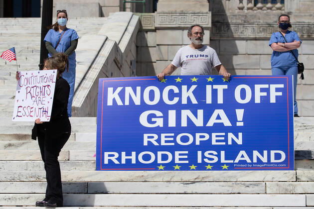 Demonstrators hold signs at a Rhode Islanders against excessive quarantine protest in reaction to the state s mandatory stay-at-home order as an attempt to combat COVID-19 at the Rhode Island State House in Providence, Rhode Island on Saturday, April 25, 2020. Rhode Island Governor Gina Raimondo has extended the stay-at-home order in an effort to combat the spread of COVID-19 to May 8th and recently told schools that they will finish the year through via distance learning. Rhode Island has had 6,699 confirmed cases of COVID-19 and 202 deaths as of Saturday.  PVD20200425110 MATTHEWxHEALEY