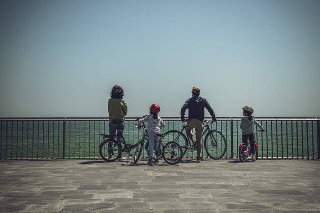 April 26, 2020: A family with two small girls overlook the closed Barceloneta beach from their bikes as Spain eases the curfew rules for under 14 years old granting them an one hour accompanied walk through the near neighborhood after six weeks of a nationwide lockdown due to the continuous spread of the corona virus. Spain registered nearly 400 new fatalities totaling a death toll close to 23000 so far. - ZUMAo105 20200426_zap_o105_014 Copyright: xMatthiasxOesterlex