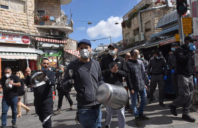 Vendors of the famous outdoor market Mahane Yehuda, protest the extended closure of the marketplace, while the Israeli government has eased coronavirus restrictions for other businesses, on Monday, April 26, in Jerusalem. The protesters banged pans and shouted against the opening of IKEA, while they are forced to remain closed.  JER2020042618 DEBBIExHILL