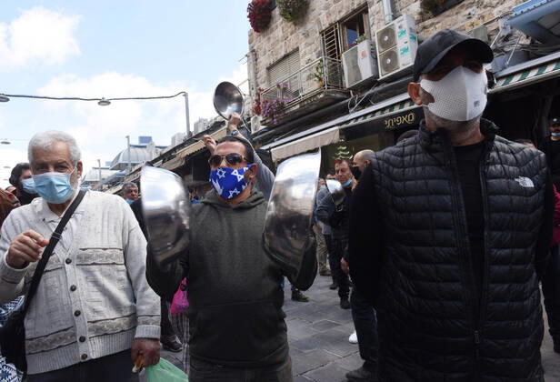 Vendors of the famous outdoor market Mahane Yehuda, protest the extended closure of the marketplace, while the Israeli government has eased coronavirus restrictions for other businesses, on Monday, April 26, in Jerusalem. The protesters banged pans and shouted against the opening of IKEA, while they are forced to remain closed.  JER2020042619 DEBBIExHILL
