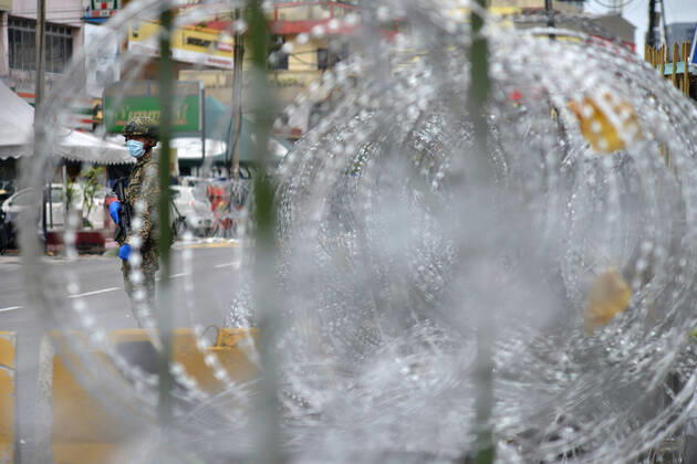 (200426) -- KUALA LUMPUR, April 26, 2020 (Xinhua) -- A soldier stands guard next to a community under the enhanced movement control order in Selayang Baru, Selangor, Malaysia, April 26, 2020. The number of new COVID-19 cases in Malaysia was kept at a double-digit for a 10th day in a row on Sunday after 38 new cases were reported, bringing the total cases to 5,780, the Health Ministry said. (Photo by Chong Voon Chung Xinhua) MALAYSIA-SELANGOR-COVID-19 