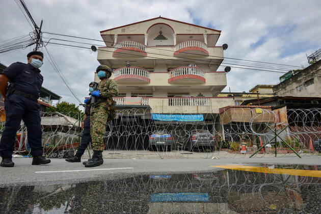 (200426) -- KUALA LUMPUR, April 26, 2020 (Xinhua) -- A soldier and police officers stand guard next to a community under the enhanced movement control order in Selayang Baru, Selangor, Malaysia, on April 26, 2020. The number of new COVID-19 cases in Malaysia was kept at a double-digit for a 10th day in a row on Sunday after 38 new cases were reported, bringing the total cases to 5,780, the Health Ministry said. (Photo by Chong Voon Chung Xinhua) MALAYSIA-SELANGOR-COVID-19 