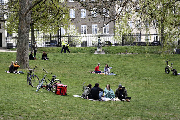 Politi patruljerer mens Koebenhavnerne nyder foraarssolen i OErstedsparken i Koebenhavn soendag den 26. april 2020. Der er forsamlingsforbud paa over ti personer paa grund af faren for smitte med coronavirus - covid-19. ** OBS billedet et optaget med et teleobjektiv og afstanden mellem personer paa billedet kan opfattes mindre en den reelt er.**.. , Copenhagen Denmark Copyright: PhilipxDavali PhilipxDavalix COP107 spdk20200426-175309-L