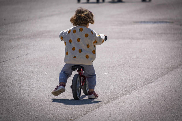 April 26, 2020, Barcelona, Spain: A child rides a bicycle on the street during the first day of allowing kids to move out for one hour with an adult..First day on the street, after 42 days of confinement, for children under 14 accompanied by an adult. The rides are limited to one hour and a maximum distance of one kilometre due to the contagion of the Covid 19. Barcelona Spain - ZUMAs197 20200426_zaa_s197_023 Copyright: xPacoxFreirex