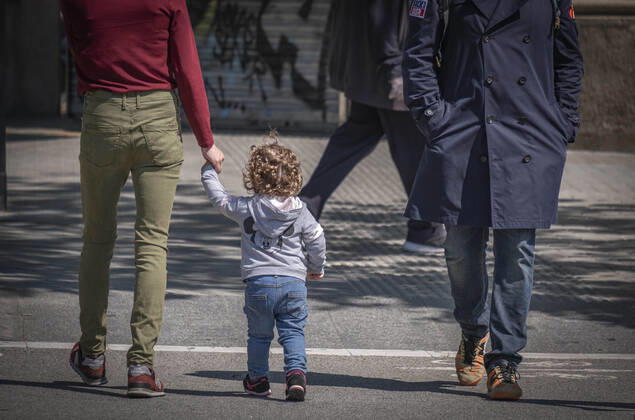 April 26, 2020, Barcelona, Spain: A man walks with a child during the first day of allowing kids to move out for one hour with an adult..First day on the street, after 42 days of confinement, for children under 14 accompanied by an adult. The rides are limited to one hour and a maximum distance of one kilometre due to the contagion of the Covid 19. Barcelona Spain - ZUMAs197 20200426_zaa_s197_025 Copyright: xPacoxFreirex