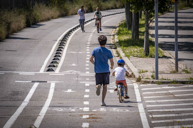 April 26, 2020, Barcelona, Spain: A man runs with a minor riding a bicycle during the first day of allowing kids to move out for one hour with an adult..First day on the street, after 42 days of confinement, for children under 14 accompanied by an adult. The rides are limited to one hour and a maximum distance of one kilometre due to the contagion of the Covid 19. Barcelona Spain - ZUMAs197 20200426_zaa_s197_037 Copyright: xPacoxFreirex