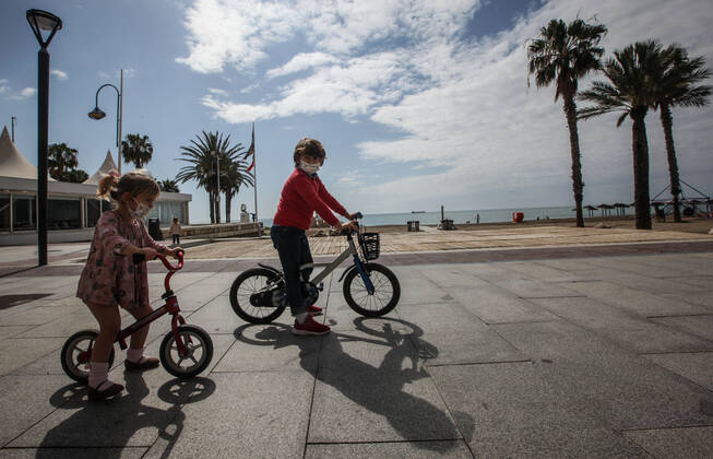 April 26, 2020: 26 April 2020 (Malaga) Thousands of children under the age of 14 go to the streets on Sunday, many on scooters and bicycles with balloons and to the beach after spending more than 40 days in solitary confinement. 42 days after the state of alarm was declared, more than six million children under the age of 14 have, as of this Sunday, permission to leave home for an hourÃ¢â‚¬â ¢s walk, and the landscape has changed in the streets. You see scooters and bicycles, even some family that has decided to go all out, the two parents with their children, when only one adult is allowed to accompany a maximum of three children within a distance of one kilometre from their home due to the coronavirus crisis - ZUMAc161 20200426_zap_c161_019 Copyright: xLorenzoxCarnerox